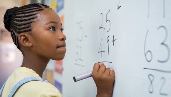 a student solving maths problem on white board