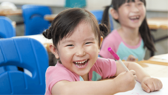 A young girl laughs as they write